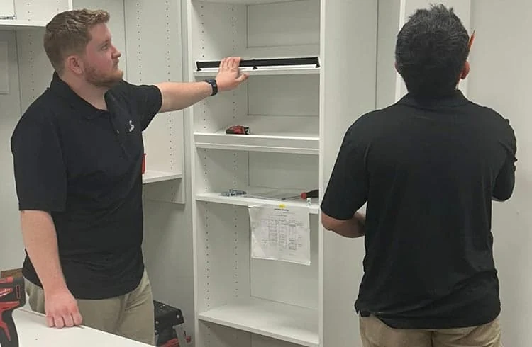 California Closets installers measuring and assembling custom cabinetry